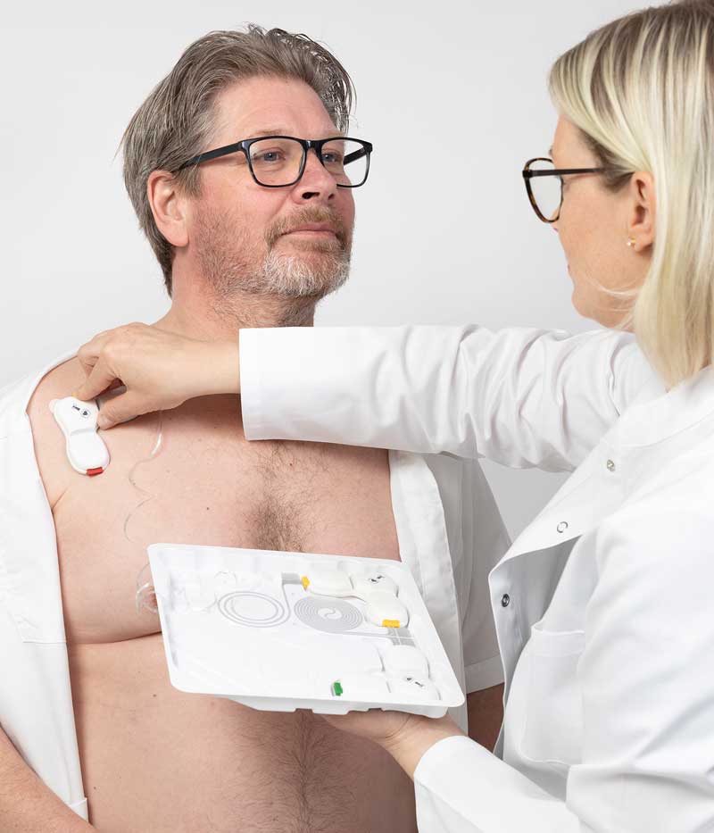 Doctor putting wearable ECG on patient